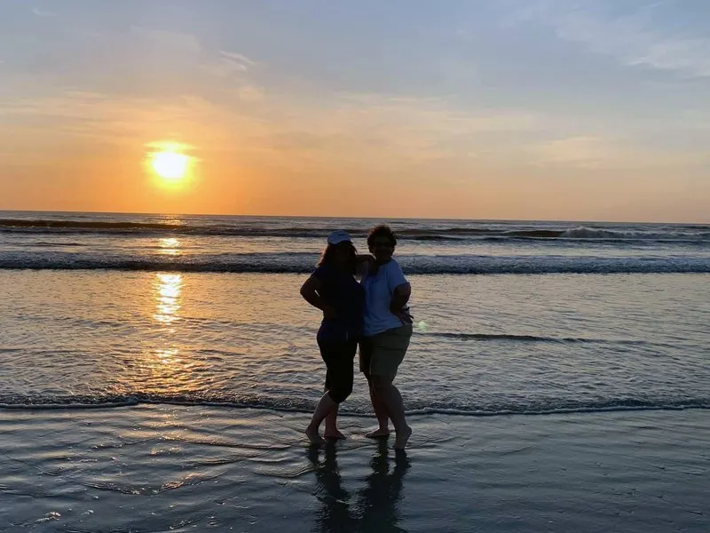 Two people on a beach at sunset